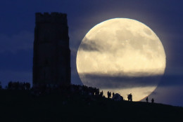 A full moon rises behind Glastonbury Tor as people gather to celebrate the summer solstice on June 20, 2016 in Somerset, England.  (Photo by Matt Cardy/Getty Images)