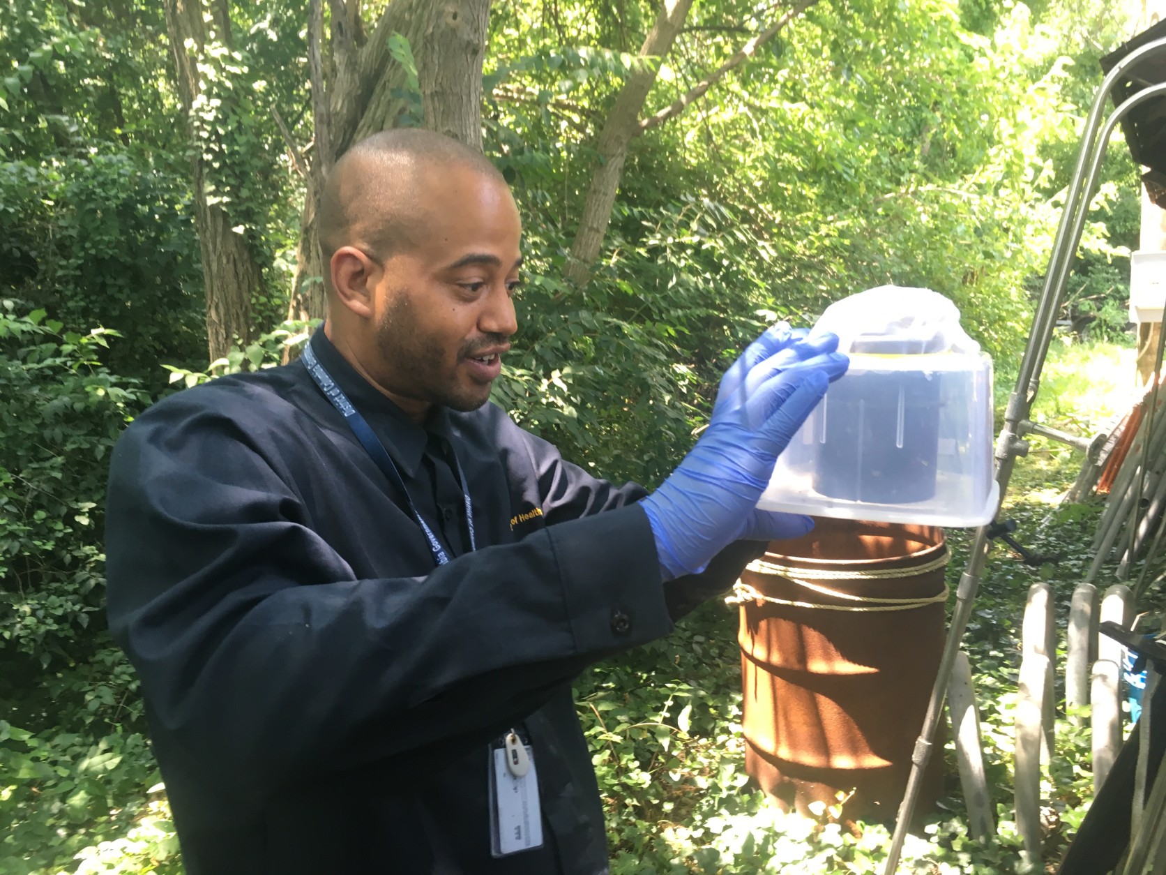 A worker from the D.C. Public Health Laboratory with one of the mosquito traps. (WTOP/Mike Murillo)
