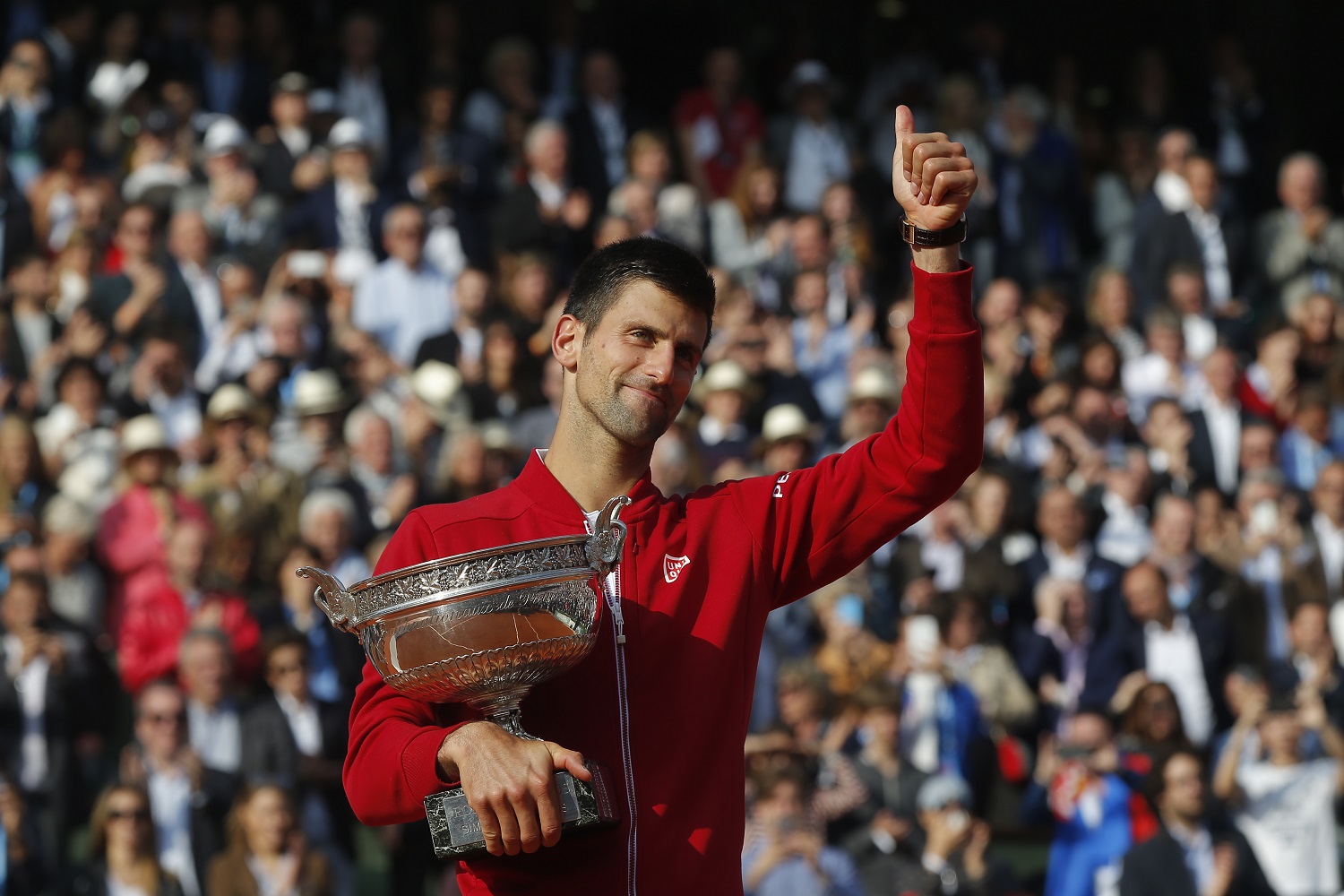 Serbia's Novak Djokovic gives a thumbs up as he holds the trophy after winning the final of the French Open tennis tournament against Britain's Andy Murray in four sets 3-6, 6-1, 6-2, 6-4, at the Roland Garros stadium in Paris, France, Sunday, June 5, 2016. (AP Photo/Michel Euler)