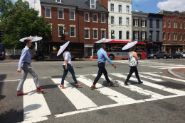 In this handout photo, four adults demonstrate the free parasols shoppers will be able to borrow to help stay cool in the hot  sun and still shop the many stores in Georgetown this summer. The new parasol-share program begins Friday, June 17, 2016. (Courtesy Georgetown Business Improvement District)