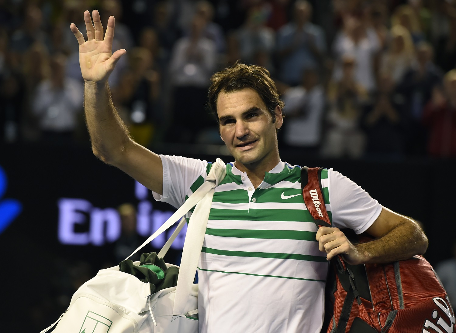 Roger Federer of Switzerland waves as he leaves Rod Laver Arena following his semifinal loss to Novak Djokovic of Serbia at the Australian Open tennis championships in Melbourne, Australia, Thursday, Jan. 28, 2016.(AP Photo/Andrew Brownbill)