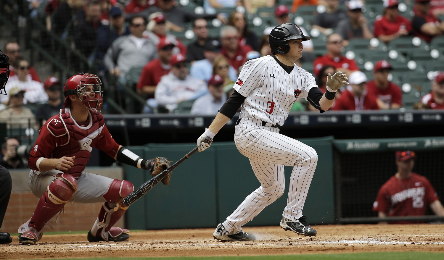 Texas Tech's Michael Davis (3) hits a two-run double as Arkansas catcher Tucker Pennell watches during the first inning of a College Classic baseball game Sunday, Feb. 28, 2016, in Houston. (AP Photo/David J. Phillip)
