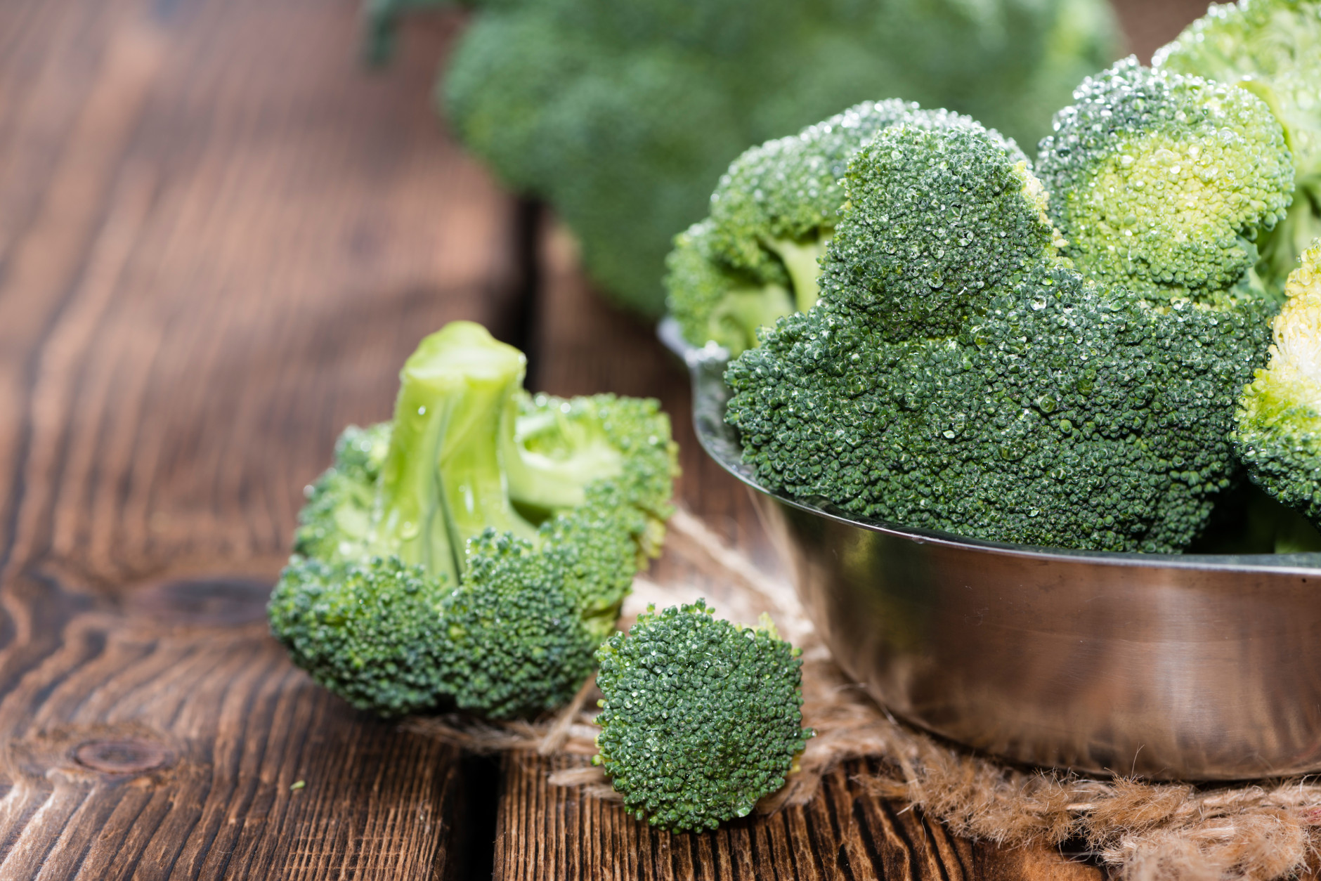 Raw Broccoli (detailed close-up shot) on wooden background