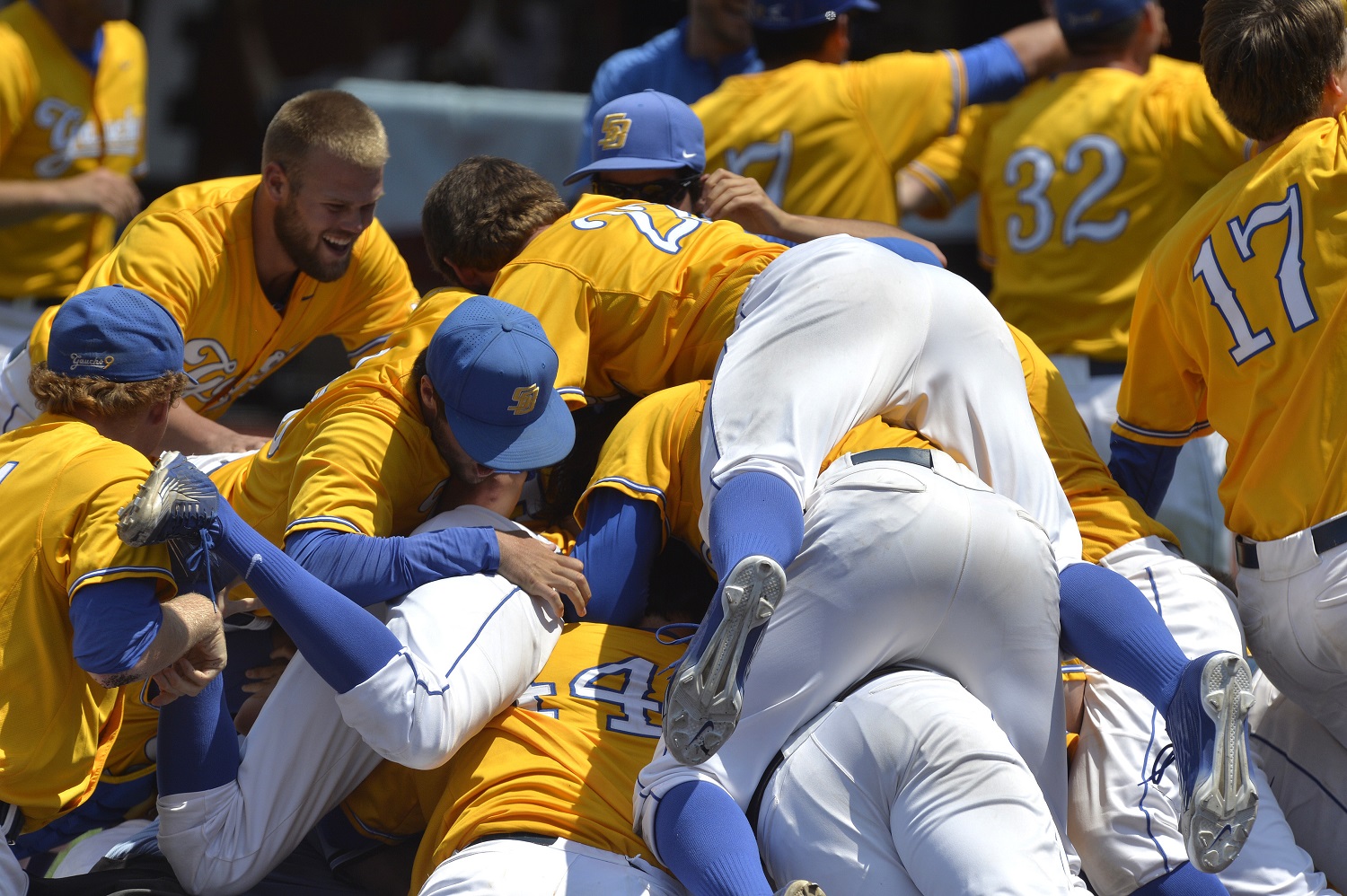 Members of UC Santa Barbara pile onto teammate Sam Cohen following his walkoff grand slam to win an NCAA college baseball tournament super regional game against Louisville, Sunday, June 12, 2016 in Louisville Ky. (AP Photo/Timothy D. Easley)