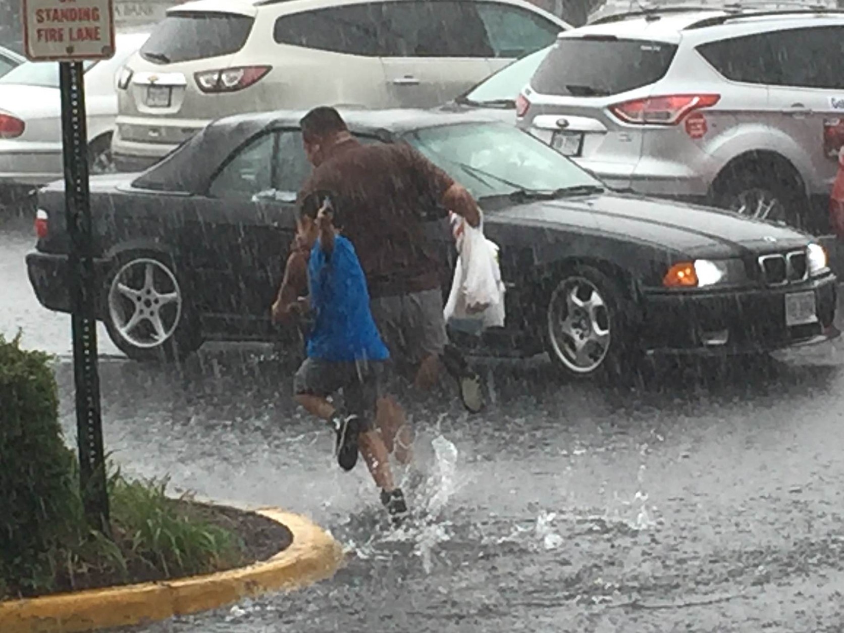 People run to their vehicles in Falls Church, Virginia during storms on June 21, 2016. (Courtesy Larry Rubenstein)