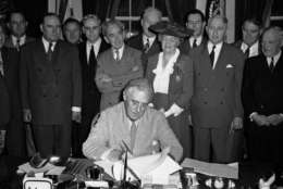 FILE - In this June 22, 1944 file photo, President Franklin D. Roosevelt puts his signature on the G.I. Bill of Rights at the White House in Washington, putting into law the measure for veterans aid.  Looking on from left are: Sen. Bennett Clark, D-Mo.; Rep. J. Harbin Peterson, D-Fla.; Rep. A. Leonard Allen, D-La.; Rep. John Rankin, D-Miss.; Rep. Paul Cunningham, R- Iowa.; Rep. Edith Nourse Rogers, R-Mass.; J.M. Sullivan; Sen. Walter George, D-Ga.; John Steele; and Sen. Robert Wagner, D-N.Y. Sullivan and Steele are American Legion officials who helped sponsor the bill.  (AP Photo/File)