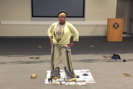 Carey Francis stands on a painting she created during her audition. (WTOP/Michelle Basch)