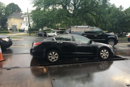 On Wisconsin Avenue in Tenleytown, a car started to sink as it drove over a metal panel on Friday, June 24, 2016. (Mike Murillo/WTOP)