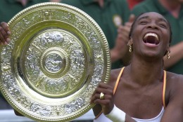 Venus Williams laughs as she holds the Women's Singles trophy  on the Centre Court at Wimbledon Saturday, July 8, 2000.  Williams defeated fellow American Lindsay Davenport in the final  6-3, 7-6 (7-3). (AP Photo/Adam Butler)
