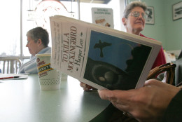 Sandra Lindley, right and Lydia Kuhn behind listens to a reader at the Krispy Kreme shop Monday, March 6, 2006, in Fresno, Calif. Kuhn and others like her spent the morning reading "To Kill a Mockingbird," as part of The National Endowment for the Arts effort to get American's to read more. The program helped kick off a month's worth of programs meant to take the classic novel where the readers are; doughnut shops, retirement homes, downtown bars, museums and yes, even libraries.(AP Photo/Gary Kazanjian)