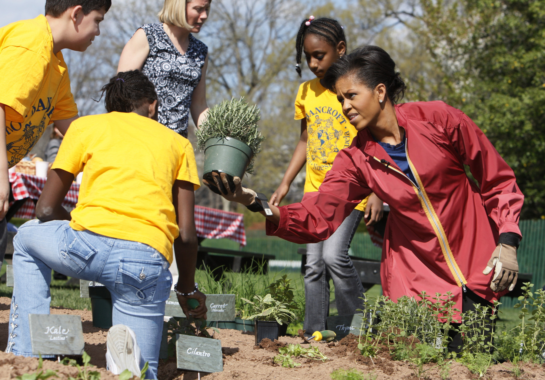 First lady Michelle Obama plants herbs on the White House Kitchen Garden with students from Bancroft Elementary School in Washington, Thursday, April 9, 2009, on the South Lawn of the White House in Washington. (AP Photo/Charles Dharapak)