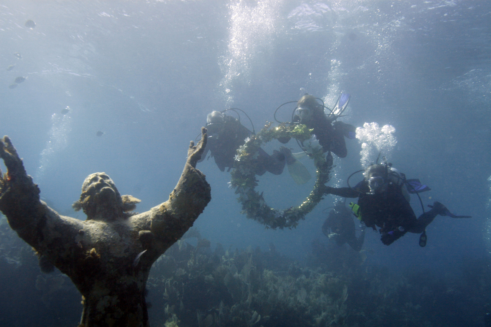 Divers Billy Causey, left, Southeast director of NOAA's national marine sanctuaries, noted oceanographer Dr. Sylvia Earle, center, and Pat Wells, John Pennekamp Coral Reef State Park manager, approach the Christ of the Abyss statue with a commemorative garland during a ceremony, Friday, Dec. 10, 2010 to commemorate the 50th anniversary celebration for the park off Key Largo, Fla., in the Florida Keys National Marine Sanctuary. (AP Photo/Wilfredo Lee)