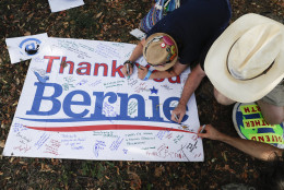 Supporters of Sen. Bernie Sanders, I-Vt., write comments on a sign following a protest march through downtown on Sunday, July 24, 2016, in Philadelphia. The Democratic National Convention starts Monday in Philadelphia. (AP Photo/John Minchillo)