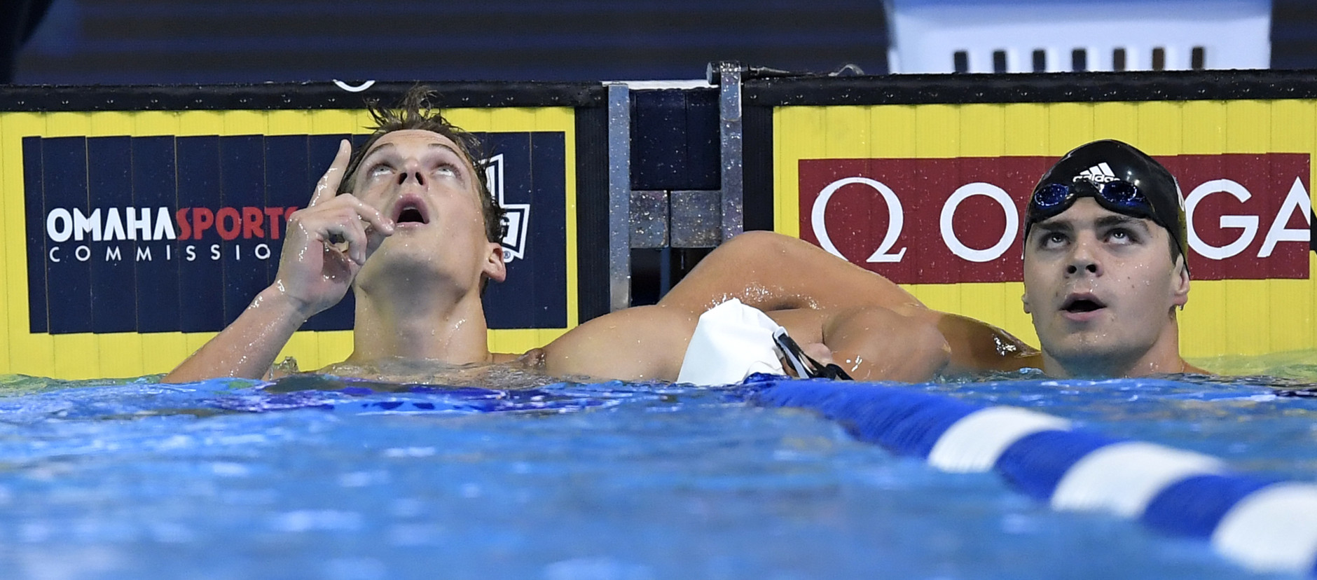 Jack Conger, left, and Matthew Josa, right, check their times after their heat in the men's 100-meter butterfly preliminaries at the U.S. Olympic swimming trials, Friday, July 1, 2016, in Omaha, Neb. (AP Photo/Mark J. Terrill)