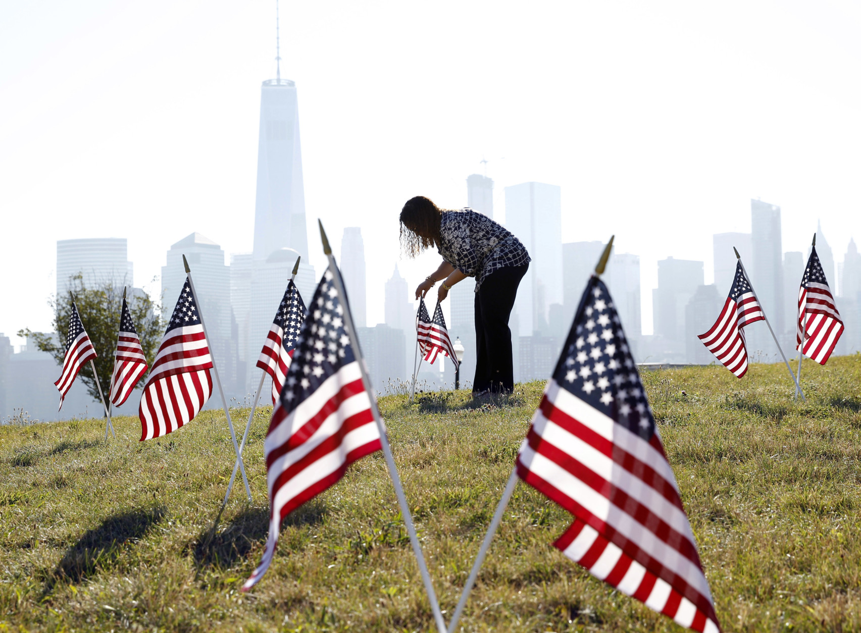 Yalenny Vargas arranges flags for the Fourth Of July celebrations at Liberty State Park on Monday, July 4, 2016, in Jersey City, N.J. (AP Photo/Mel Evans)