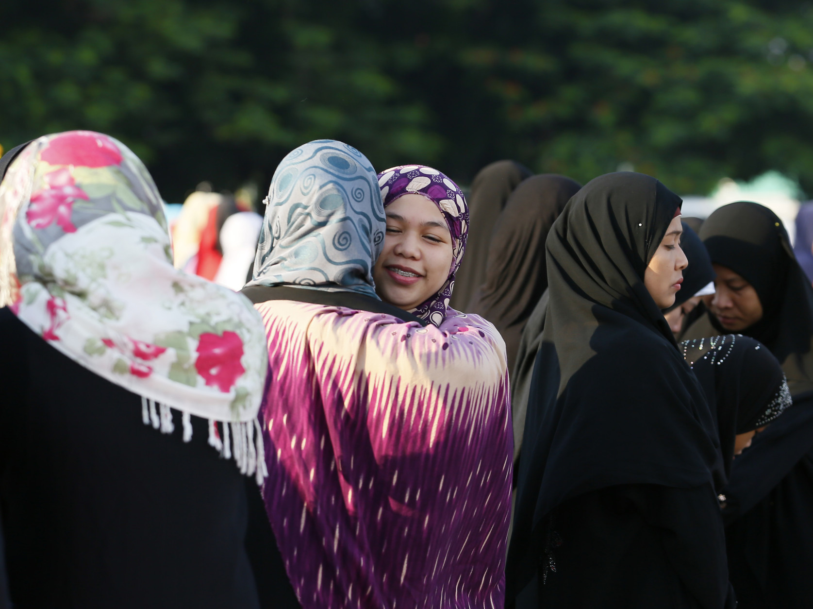 Muslims greet each other as they gather for prayer to mark the end of the holy month of Ramadan known as Eid al Fitr, Wednesday, July 6, 2016 in Manila, Philippines. The Eid, one of the most important holidays in the Muslim world, is celebrated with prayers, picnics and family reunions. (AP Photo/Bullit Marquez)