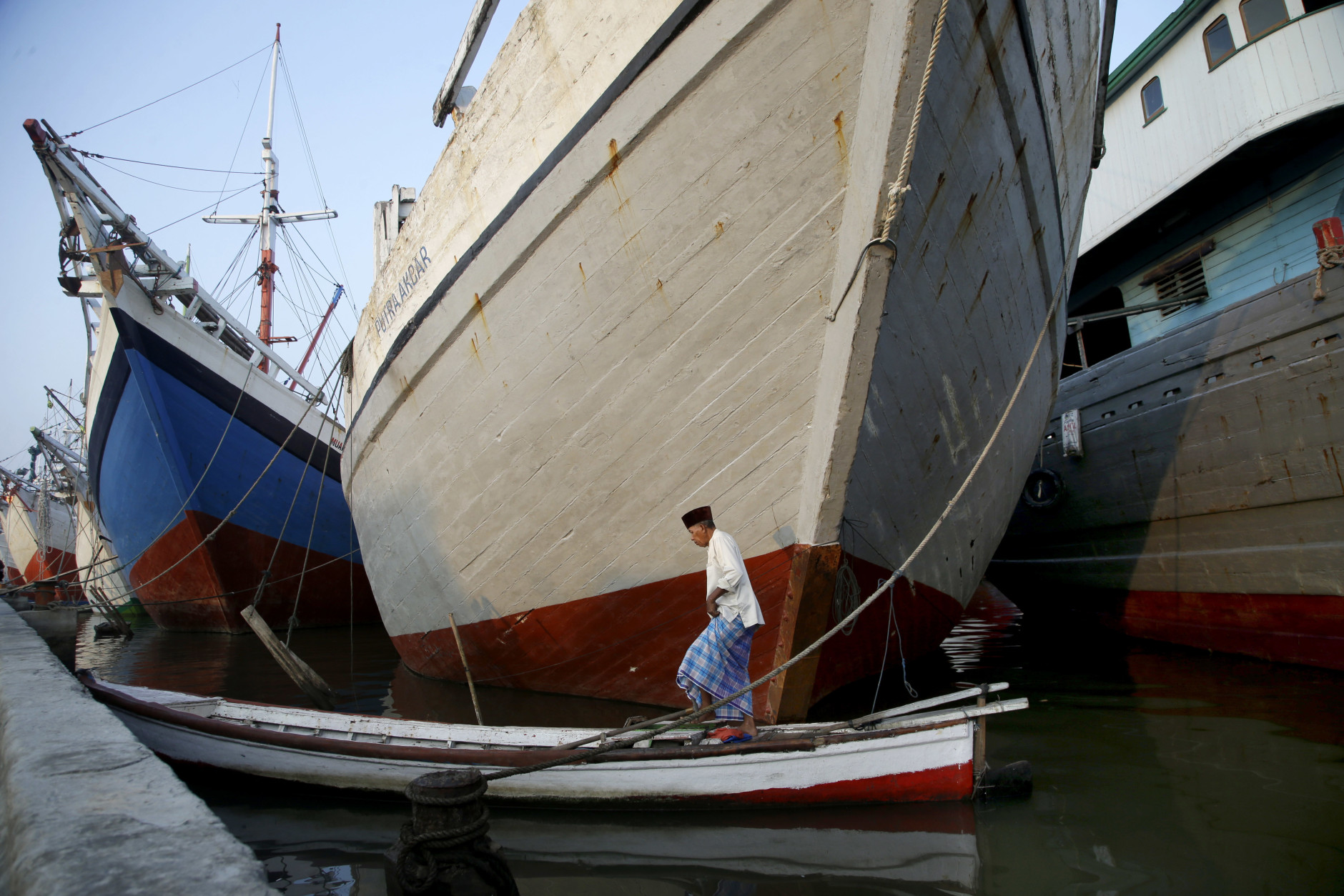 An Indonesian Muslim man arrive on a boat for an Eid al-Fitr prayer to mark the end of the holy fasting month of Ramadan at Sunda Kelapa port in Jakarta, Indonesia, Wednesday, July 6, 2016. (AP Photo/Tatan Syuflana)