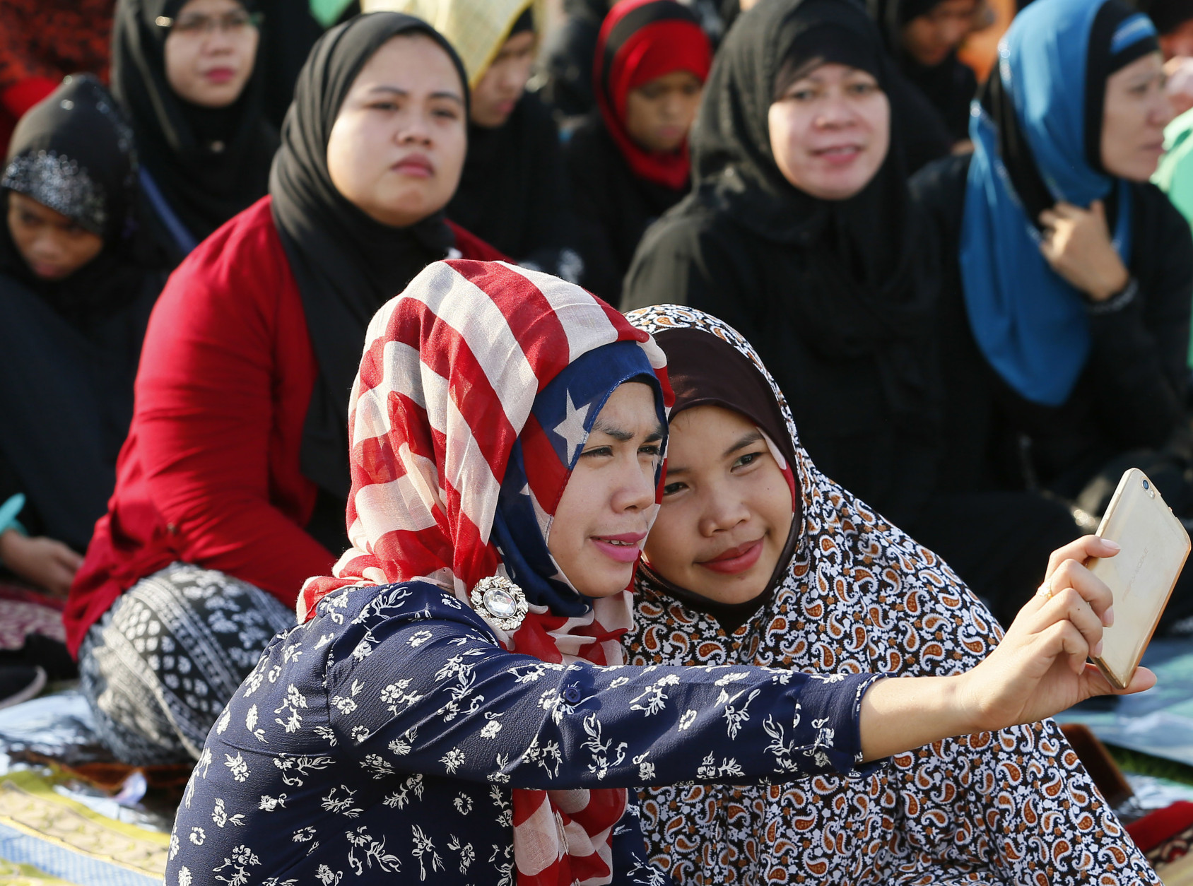 Muslims take their selfie photograph as they gather for prayer to mark the end of the holy month of Ramadan known as Eid al Fitr, Wednesday, July 6, 2016 in Manila, Philippines. The Eid, one of the most important holidays in the Muslim world, is celebrated with prayers, picnics and family reunions. (AP Photo/Bullit Marquez)