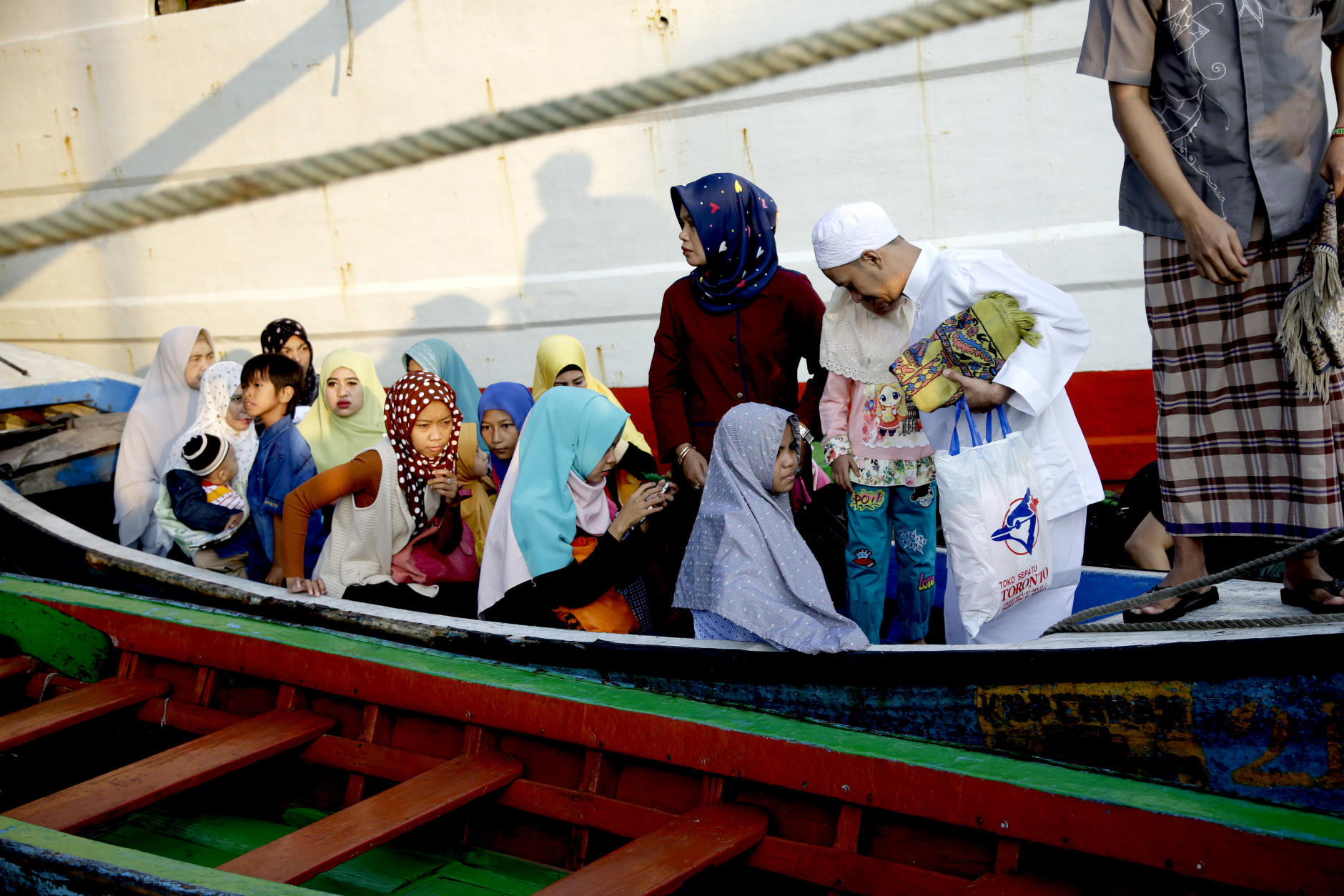 Indonesian Muslims arrive on boats for an Eid al-Fitr prayer to mark the end of the holy fasting month of Ramadan at Sunda Kelapa port in Jakarta, Indonesia, Wednesday, July 6, 2016. (AP Photo/Tatan Syuflana)
