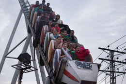Pakistani youth react while enjoying a ride at a fair to celebrate the Eid al-Fitr holidays in Rawalpindi, Pakistan, Wednesday, July 6, 2016. Eid al-Fitr marks the end of the Islamic holy Islamic month of Ramadan, during which devout Muslims all over the world fast from sunrise to sunset. (AP Photo/Anjum Naveed)