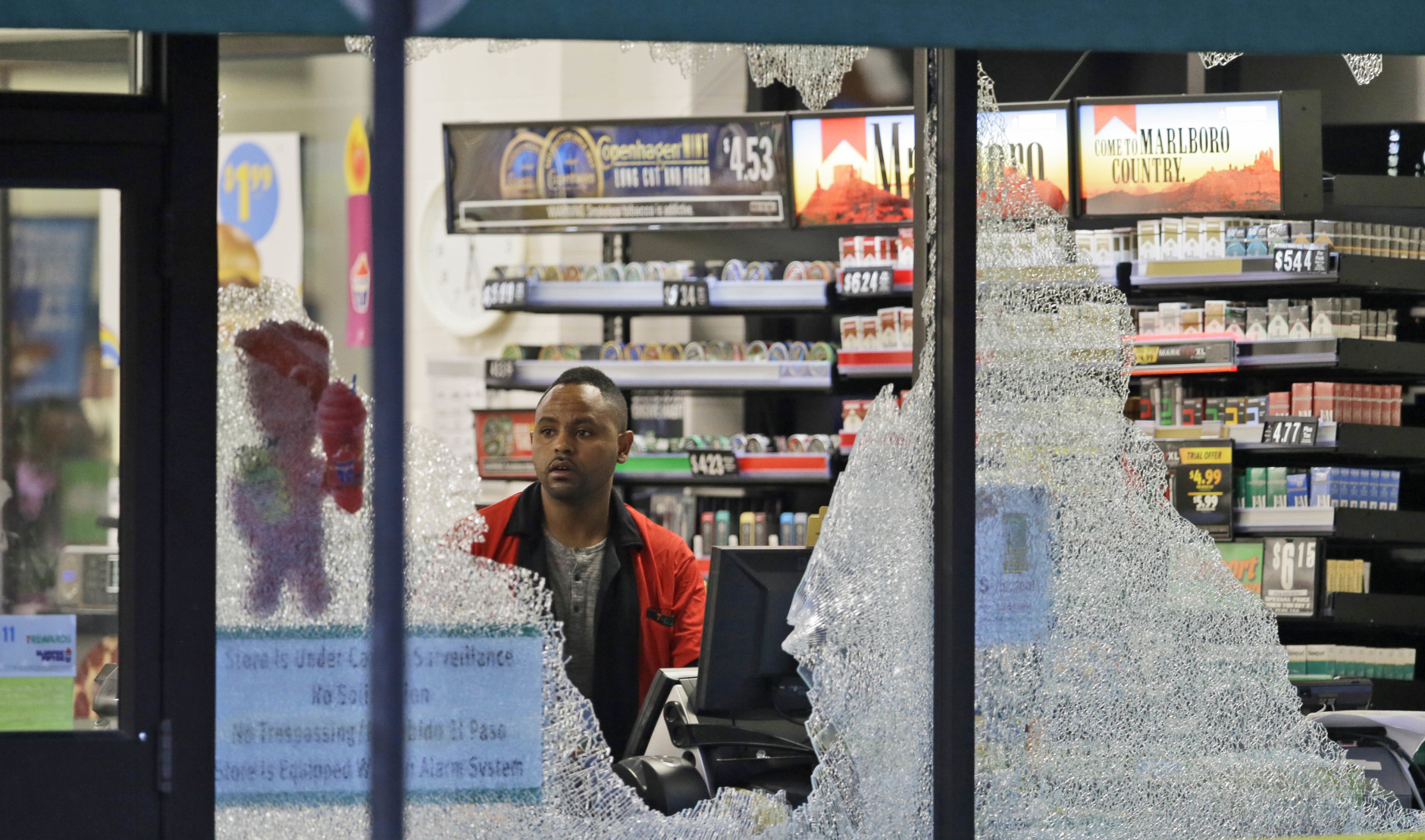 A clerk looks at broke windows shot out at a store in downtown Dallas, Friday, July 8, 2016.  Snipers opened fire on police officers in the heart of Dallas during protests over two recent fatal police shootings of black men.(AP Photo/LM Otero)