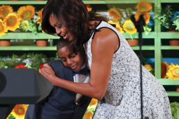 First Lady Michelle Obama, hugs Samuel Davis, 12, from Shreveport, La., the 2015 Healthy Lunchtime Challenge winner, at the 2016 Kids' State Dinner in the East Room of the White House in Washington, Thursday, July 14, 2016. The event is hosted by first lady Michelle Obama and is part the Healthy Lunchtime Challenge inviting 8 to 12-years-olds across the country to create healthy, affordable, original, and delicious lunch recipes. (AP Photo/Pablo Martinez Monsivais)