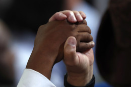 Two people join hands during the closing benediction on the final day of the Democratic National Convention in Philadelphia, Thursday, July 28, 2016. (AP Photo/Paul Sancya)