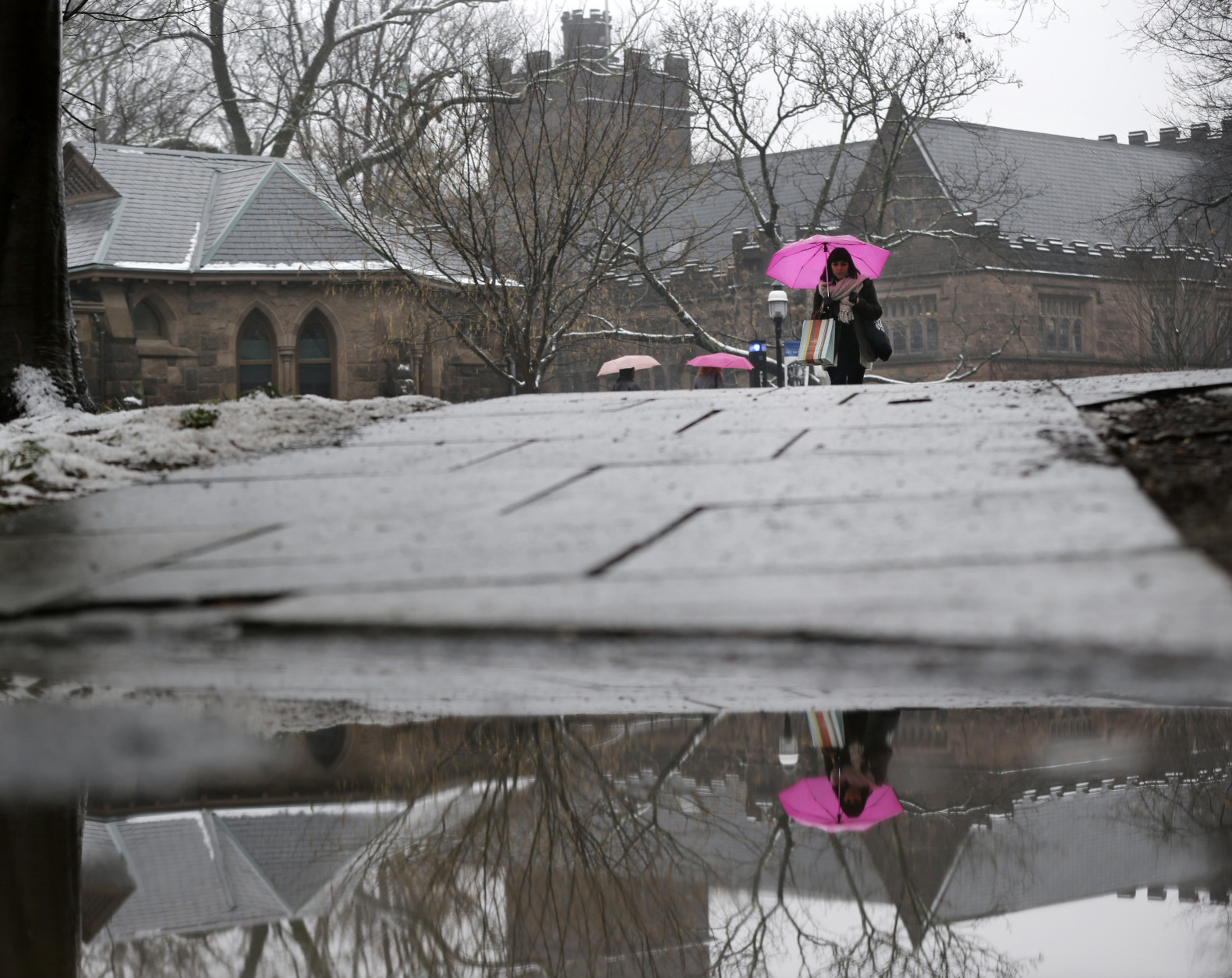 People use umbrellas as they walk at Princeton University in Princeton, N.J., Monday, Dec. 9, 2013. (AP Photo/Mel Evans)