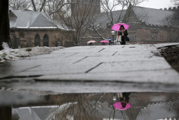 People use umbrellas as they walk at Princeton University in Princeton, N.J., Monday, Dec. 9, 2013. (AP Photo/Mel Evans)