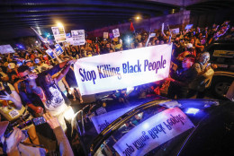 Black Lives Matter demonstrators gather at the police vehicle stuck facing northbound during a protest march south on Broad Street in Philadelphia, Tuesday, July 26, 2016, during the second day of the Democratic National Convention. (AP Photo/John Minchillo)