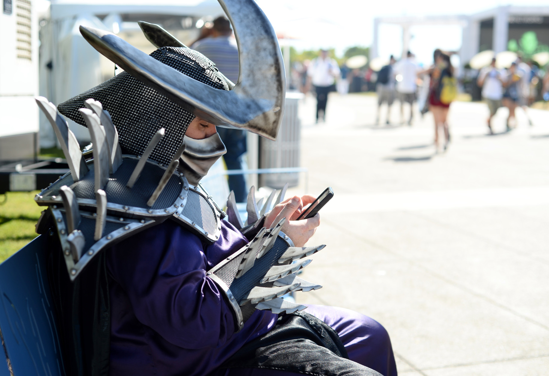A fan dressed as Super Shredder checks his Instagram on day 2 of Comic-Con International on Friday, July 22, 2016, in San Diego. (Photo by Al Powers/Invision/AP)