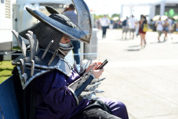 A fan dressed as Super Shredder checks his Instagram on day 2 of Comic-Con International on Friday, July 22, 2016, in San Diego. (Photo by Al Powers/Invision/AP)