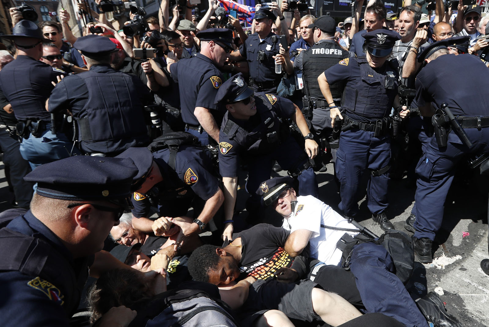 Police and protesters fall to ground during demonstration, Wednesday, July 20, 2016, in Cleveland, during the third day of the Republican convention. (AP Photo/John Minchillo)