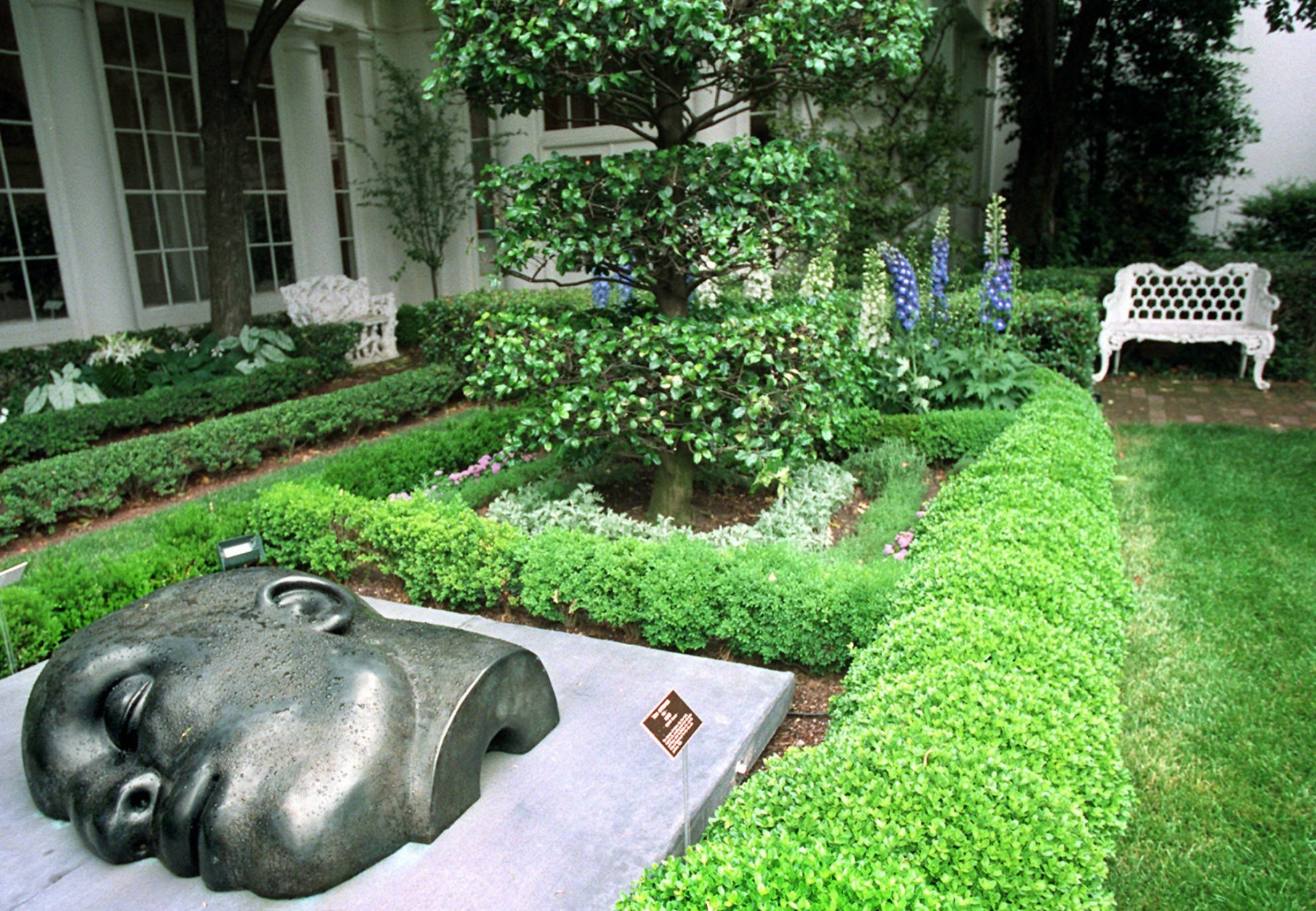 "Head" by Tom Otterness is shown Wednesday, June 12, 1996 in the First Lady's Garden at the White House. The sculpture is on loan and part of a rotating exhibit. The White House garden is a place where roses are named for Nancy Reagan and Pat Nixon, and a tulip for Hillary Rodham Clinton. It is a garden that shows off with the fire of red tulips in the spring and a quilt of bronze and gold chrysanthemums in the fall. (AP Photo/Ruth Fremson)