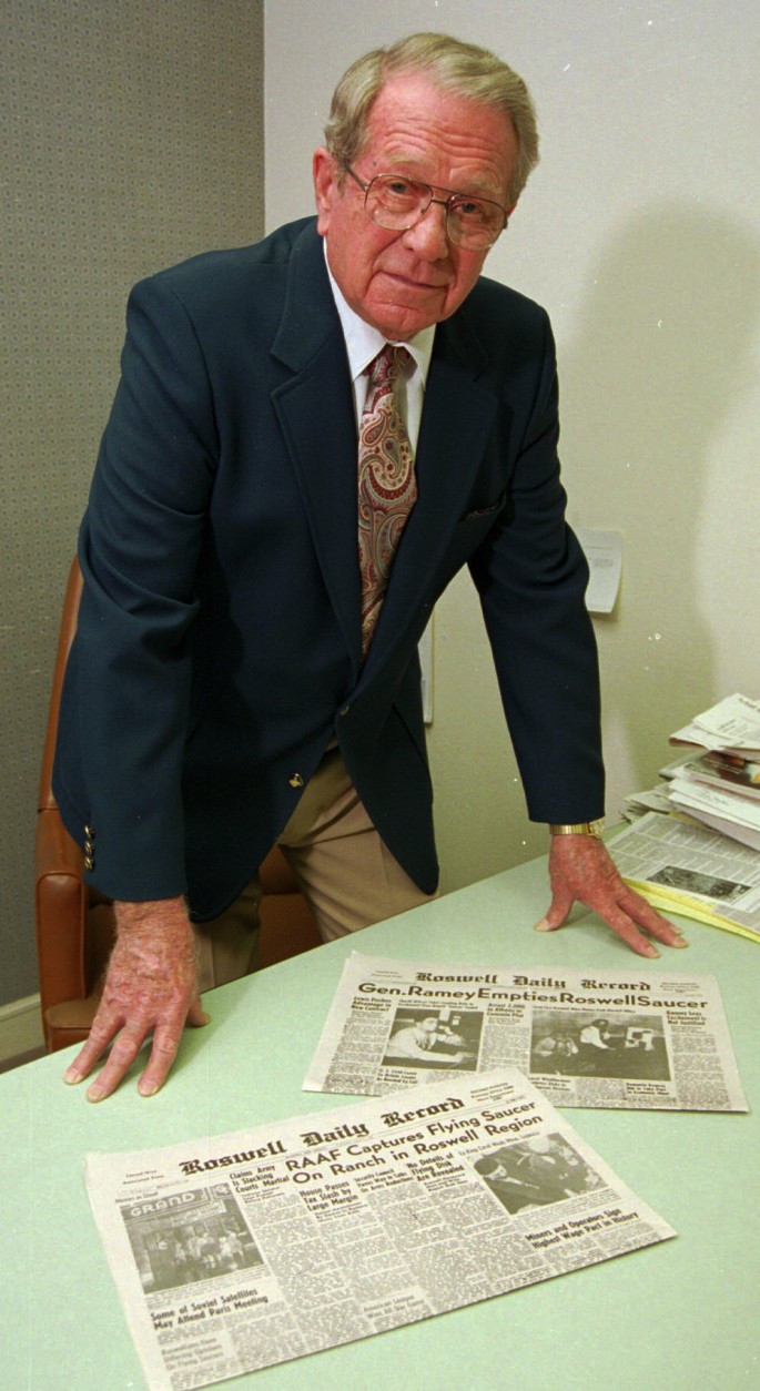 FILE--Walter Haut, posing July, 1994 in Roswell, N.M., displays front-page copies of the Roswell Daily Record's July 8, and July 9, 1947 editions featuring a reported UFO crash near Roswell. Haut was the public information officer at Roswell Army Air Field who released the report of the military recovering a flying saucer. (AP photo/Roswell Daily Record/Mike Pettit, files)