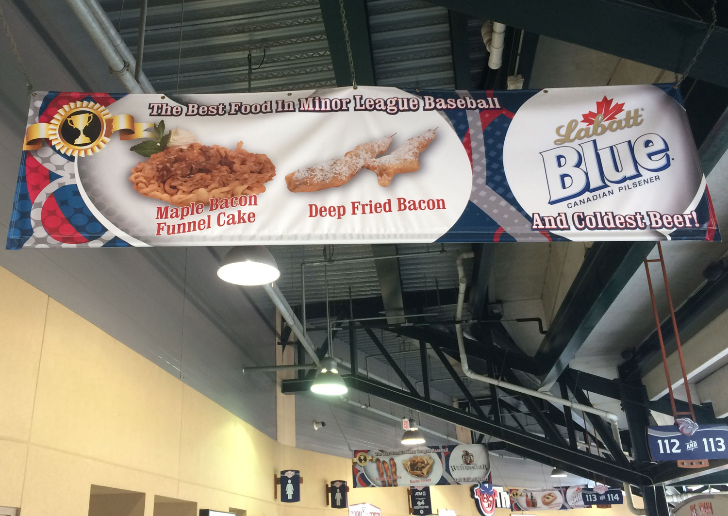 Signs proclaim "the best concessions in minor league baseball," many of which include bacon. (WTOP/Noah Frank)