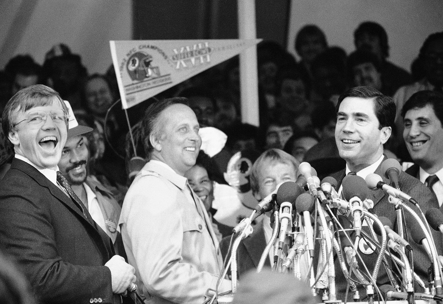 Washington Redskins Head Coach Joe Gibbs, left, reacts to the reading of a proclamation honoring the Redskins by Virginia Governor Chuck Robb, right, Wednesday, Feb. 2, 1983, Washington, D.C. Behind Gibbs is Redskins Fred Dean and in the center is Frank Herzog, the master of ceremonies. (AP Photo)