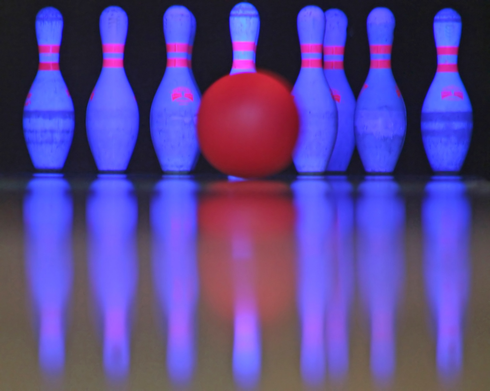 A bowling ball just about to hit the pins.