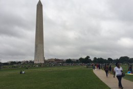 The Washington Monument is seen as crowds gathered in early July. (WTOP/Michelle Basch)