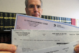 In this Monday, June 11, 2012 photo, Assistant Attorney General David Kirkman holds checks of the type often received by targets in his Raleigh, N.C., office. The recipient forwarded them to his office. Kirkman said sometimes the checks carry the names and account numbers of legitimate companies, and by the time a bank confirms they're bogus, the victim has usually sent the amount to the scammer via wire and ends up on the hook for the money. He also said the amount of money swindled from North Carolinians by these scams has doubled in the past year. (AP Photo/Allen Breed)