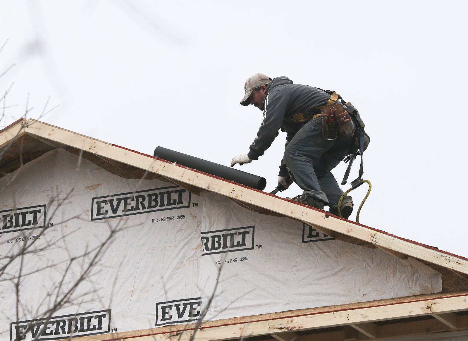In this Tuesday, Jan. 26, 2016, photo, a man installs a roof on a new home under construction in Atlanta. On Tuesday, Feb. 16, 2016, the National Association of Home Builders/Wells Fargo releases its February index of builder sentiment. (AP Photo/John Bazemore)