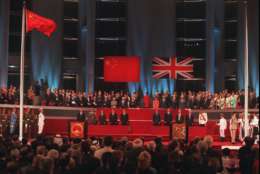 World dignitaries and other guests to the Hong Kong handover ceremony stand and watch the Chinese flag, left, flying after the Union Jack was lowered at the Hong Kong Convention Center Tuesday, July 1, 1997. (AP Photo/Kimimasa Mayama, Pool)