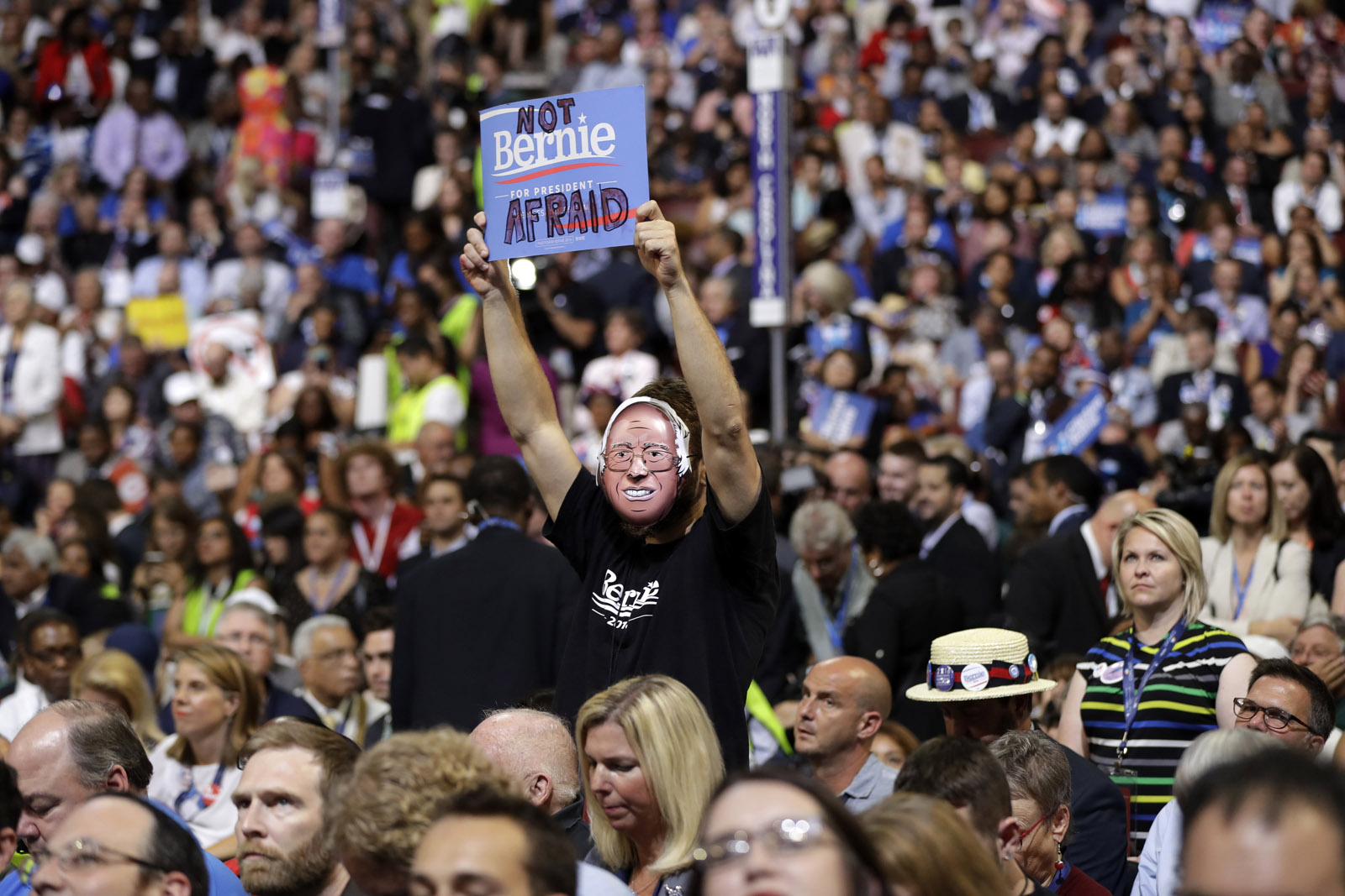 Supporter for former Democratic presidential candidate, Sen. Bernie Sanders, I-Vt., holds up a sign as President Barack Obama speaks during the third day session of the Democratic National Convention in Philadelphia, Wednesday, July 27, 2016. (AP Photo/Matt Rourke)