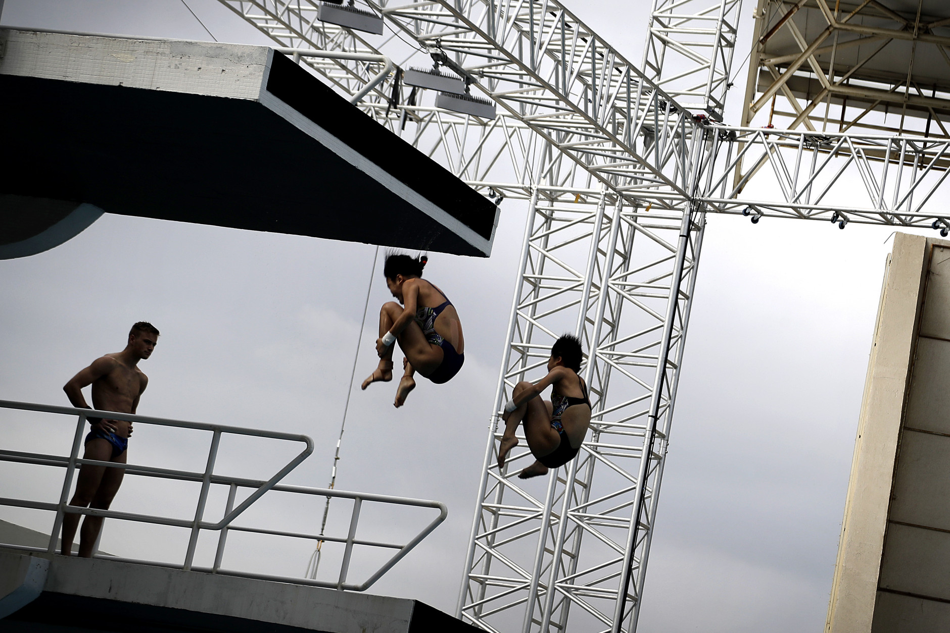 Divers are seen in silhouette as they take part in a training session in the Maria Lenk Aquatic Center ahead of the 2016 Summer Olympics in Rio de Janeiro, Brazil, Wednesday, Aug. 3, 2016. (AP Photo/Wong Maye-E)
