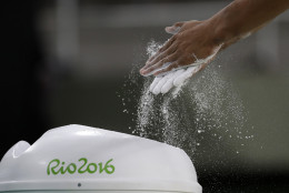 Gymnast Marios Georgiou from Cyprus rubs chalk on his hand before performing on an apparatus ahead of the 2016 Summer Olympics in Rio de Janeiro, Brazil, Wednesday, Aug. 3, 2016. (AP Photo/Julio Cortez)