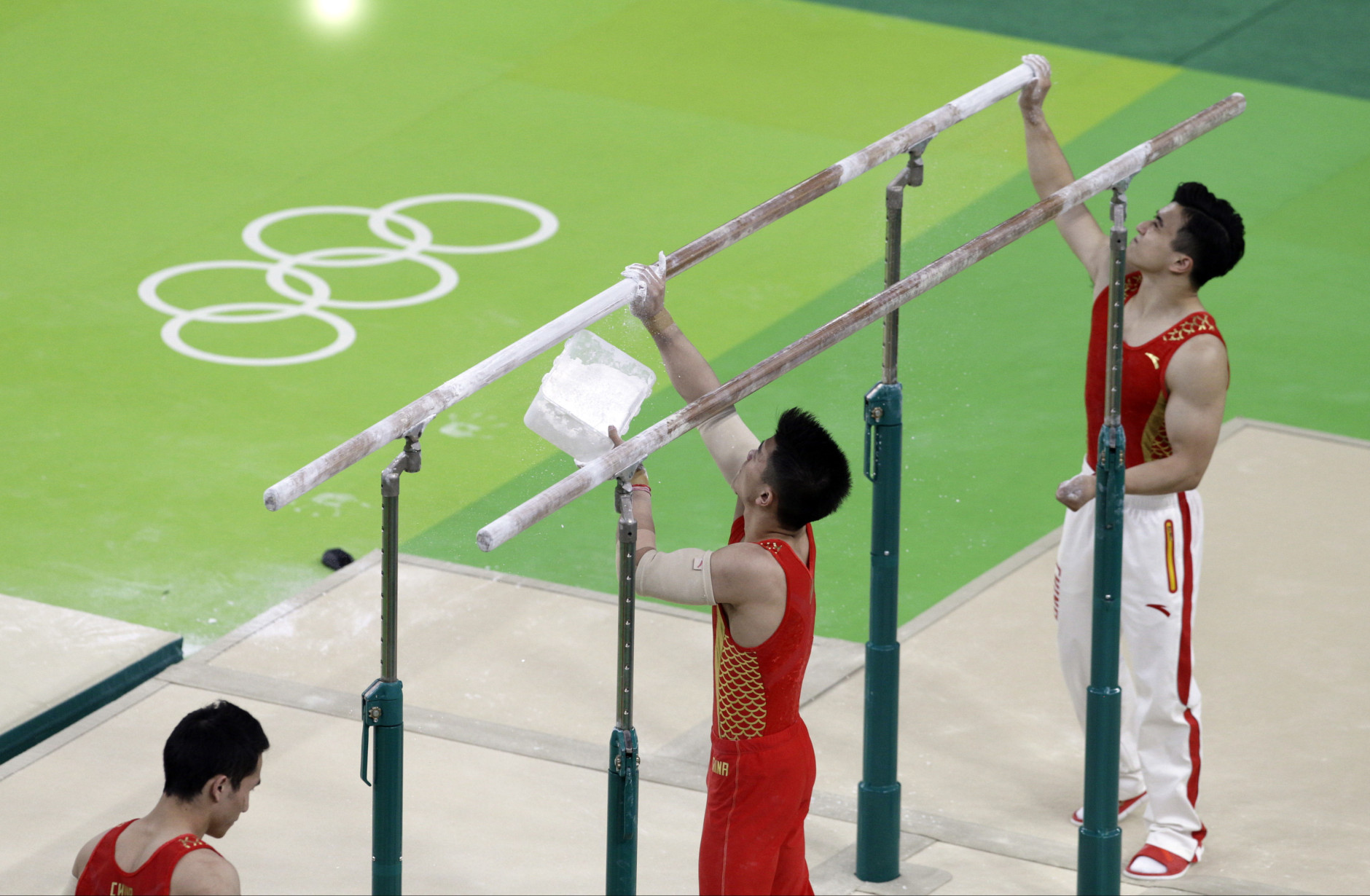 Members of the Chinese gymnastics team prepare the parallel bars before a training session ahead of the 2016 Summer Olympics in Rio de Janeiro, Brazil, Wednesday, Aug. 3, 2016. (AP Photo/Rebecca Blackwell)