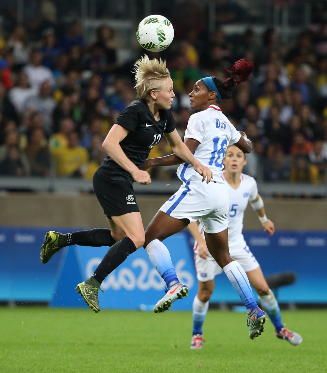 New Zealand's Betsy Hassett, left, and United States' Crystal Dunn jump for the ball during a women's Olympic football tournament match at the Mineirao stadium in Belo Horizonte, Brazil, Wednesday, Aug. 3, 2016. United States won 2-0. (AP Photo/Eugenio Savio)