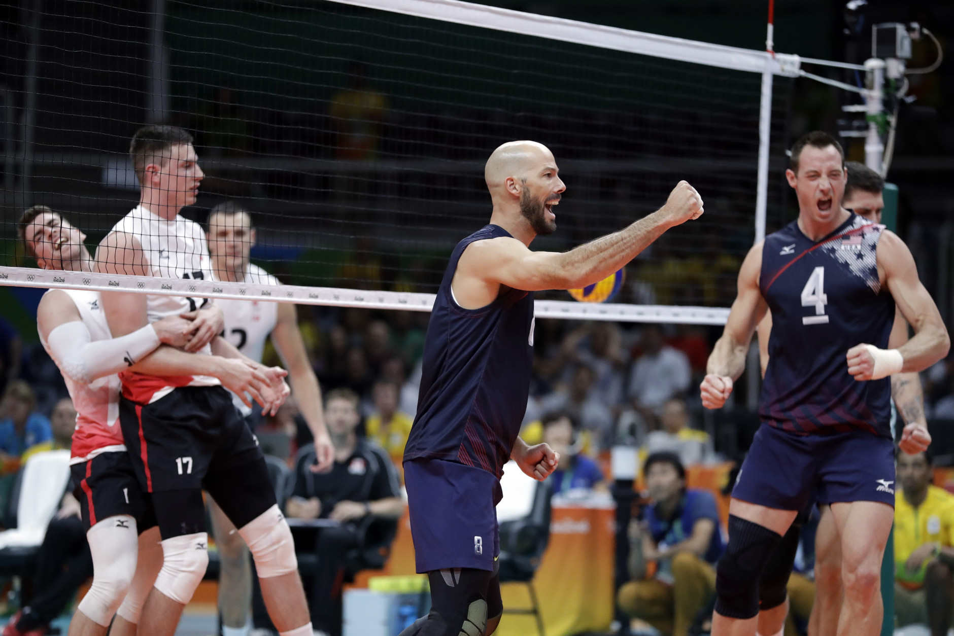 United States' William Reid Priddy, center, and David Lee, right, celebrate during a men's preliminary volleyball match against Canada at the 2016 Summer Olympics in Rio de Janeiro, Brazil, Sunday, Aug. 7, 2016. (AP Photo/Jeff Roberson)