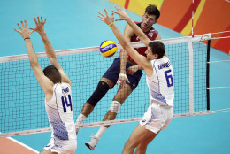 United States' Aaron Russell, top right, spikes the ball as Italy's Simone Giannelli (6) and Matteo Piano block during a men's preliminary volleyball match at the 2016 Summer Olympics in Rio de Janeiro, Brazil, Tuesday, Aug. 9, 2016. (AP Photo/Matt Rourke)