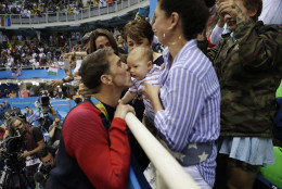 United States' Michael Phelps celebrates winning his gold medal in the men's 200-meter butterfly with his mother Debbie, fiance Nicole Johnson and baby Boomer during the swimming competitions at the 2016 Summer Olympics, Tuesday, Aug. 9, 2016, in Rio de Janeiro, Brazil. (AP Photo/Matt Slocum)